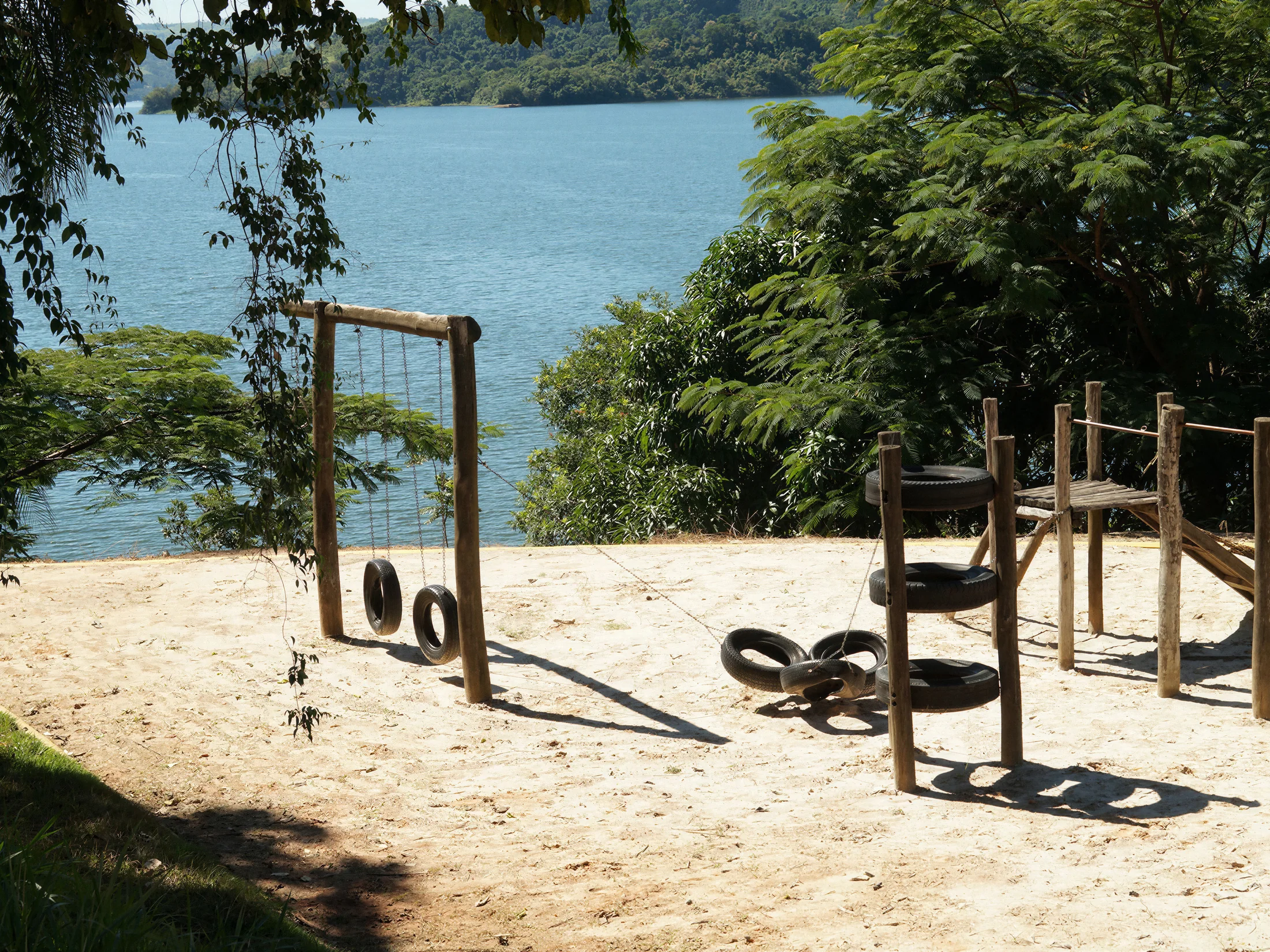 Parquinho infantil do Pier 22, em areia, com a represa ao fundo