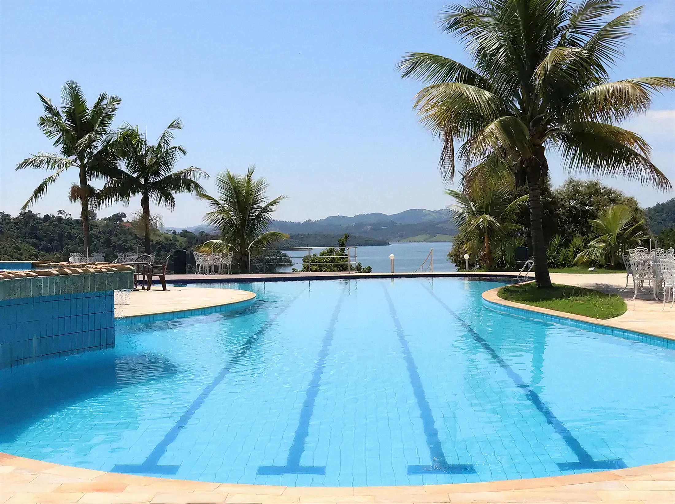 Piscina adulto com raias de natação do Pier 22, com palmeiras e a represa ao fundo